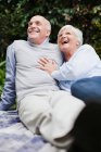 Older couple relaxing together outdoors — Stock Photo