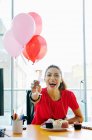 Geschäftsfrau mit rosa Luftballons stößt auf Büroparty an — Stockfoto