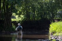 Vola pescatore gettando una linea nel fiume — Foto stock