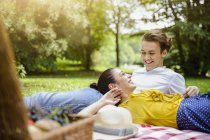 Young couple lying together on picnic blanket — Stock Photo