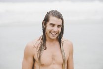 Мужчина с длинными волосами и широкой улыбкой — стоковое фото