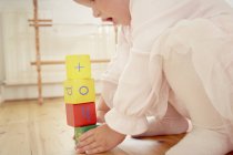 Abgeschnittene Aufnahme von Baby-Mädchen, das Stapel mit Bausteinen baut — Stockfoto