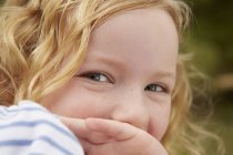 Close up retrato de menina com a mão cobrindo boca — Fotografia de Stock