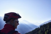 Mountainbiker mit Helm in den Bergen, Wallis, Schweiz — Stockfoto