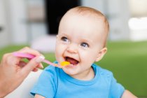 Baby sitting in chair being fed — Stock Photo