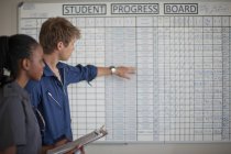 Pilotos estudiantiles revisando tablero de progreso - foto de stock