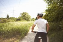 Cyclist stopping for break on countryside road in summer — Stock Photo