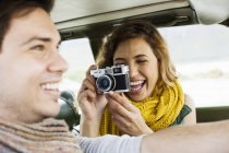 Young woman photographing boyfriend whilst driving, Cape Town, Western Cape, South Africa — Stock Photo