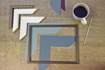 Still life of frames and coffee in picture framers workshop — Stock Photo