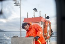 Частичный вид рыбака, очищающего рыбацкую лодку — стоковое фото