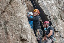 Три альпіністи на скелі — стокове фото
