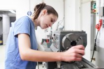 Female engineer checking machine in workshop — Stock Photo