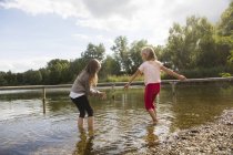 Две девочки гребут в озере — стоковое фото