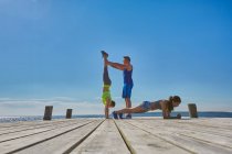 Friends on pier doing handstands and push ups — Stock Photo