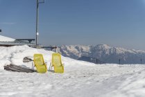 Duas espreguiçadeiras amarelas na neve — Fotografia de Stock