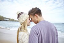 Pareja joven y romántica cara a cara en la playa, Constantine Bay, Cornwall, Reino Unido - foto de stock