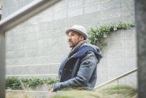 Portrait of man in coat and hat looking away — Stock Photo