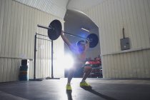 Moyen homme adulte levant haltère dans la salle de gym — Photo de stock