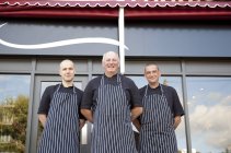 Portrait of three male butchers outside butchers shop — Stock Photo