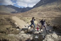 Familie überquert Bach, Feenpools, Insel Skye, Hebriden, Schottland — Stockfoto