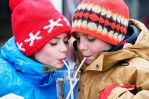 Двоє дітей п'ють склянку води — стокове фото