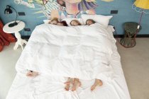 Quatre jeunes femmes amies endormies dans le lit de l'hôtel — Photo de stock