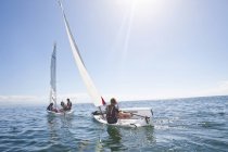 Junge erwachsene Freunde rasen in Segelbooten auf See gegeneinander — Stockfoto
