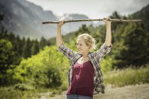 Teenager-Wanderin hält Spazierstock auf Landstraße hoch, rote Hütte, Montana, USA — Stockfoto