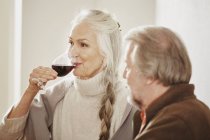 Senior mulher bebendo vinho tinto — Fotografia de Stock