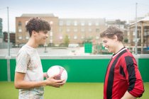 Два юноши играют в футбол на городском футбольном поле — стоковое фото