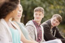 Four young adult friends chatting in park — Stock Photo
