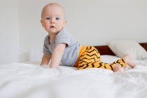 Porträt eines kleinen Mädchens, das auf dem Bett kriecht — Stockfoto