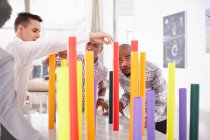 Коллеги по построению команды балансируют разноцветные трубки — стоковое фото