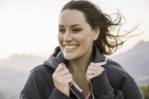 Portrait of woman wearing hooded top looking away smiling — Stock Photo