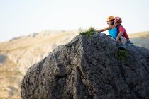 Bergsteigerpaar sitzt auf Felsen — Stockfoto