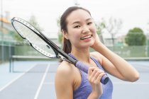 Retrato de una joven tenista en una cancha de tenis - foto de stock