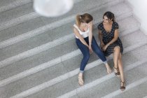 Женщины, сидящие на лестнице, обсуждают, высокий угол зрения — стоковое фото
