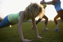 Portrait of woman doing push up exercise in park — Stock Photo