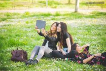 Young female friends taking selfie in park — Stock Photo