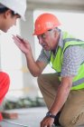 Old worker talking to young worker — Stock Photo