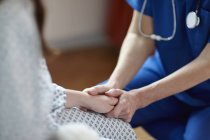 Immagine ritagliata dell'infermiera che tiene la mano del paziente — Foto stock