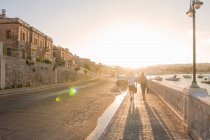 Paar spaziert bei Sonnenuntergang am Hafen entlang, ta xbiex, gzira, malta — Stockfoto