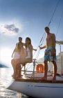 Group on back of sailboat smile — Stock Photo