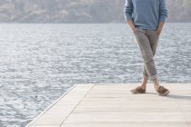 Veduta ritagliata del giovane in piedi sul molo, Lago Mergozzo, Verbania, Piemonte, Italia — Foto stock