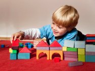 Хлопчик з іграшковими будівельними блоками — стокове фото