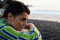 Портрет жінки, що сидить на пляжі — стокове фото