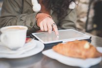 Обрізаний знімок молодої жінки, використовуючи сенсорний екран на цифровому планшеті в тротуарному кафе — стокове фото