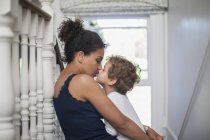 Mãe e filho sentados nas escadas, filho beijando mãe — Fotografia de Stock