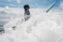 Niño surfeando a través de las olas - foto de stock