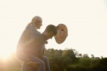 Giovane uomo dando fidanzata un cavalluccio — Foto stock